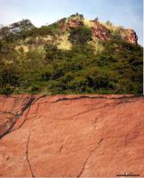 Figura 10. Arenito silicificado em exposições de superfície, lajes ou paredões nas encostas dos morros. A rocha apresenta aspecto em geral maciço, cor marrom alaranjado a rosado.
