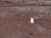 Feições sedimentares onduladas truncadas e cruzadas bem marcadas na base do morro arenítico.