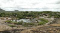 Vista panorâmica do geossítio Lagoa da Cunhã, onde se observa material saprolítico no entorno da lagoa, com inúmeros blocos exumados (previamente sapro-rochas). Foto: Rogério Valença Ferreira.