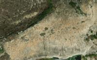 Vista aérea do sítio Lajedo Salambaia, onde pode-se observar a presença de inúmeras feições de bacias de dissolução (cacimbas) e caneluras. Fonte: Google Earth, imagem capturada em  21/09/2018.
