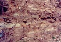 Estratificação cruzada sigmoidal dos arenitos nos paredões da pedreira de Morro do Chapéu.  Foto: Antônio J. Dourado Rocha, 1996.